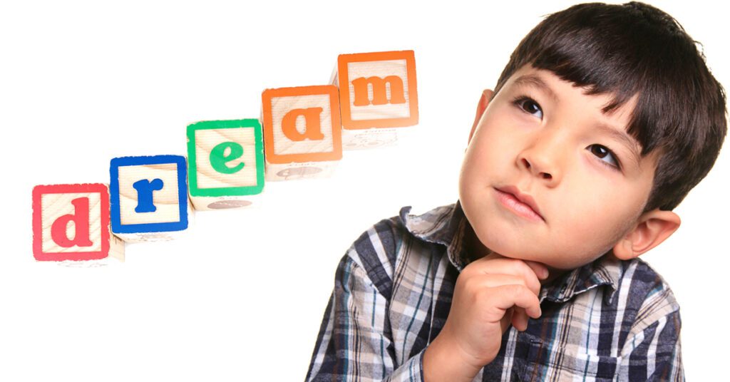 daydreaming A young boy with blocks that spell out "dream"